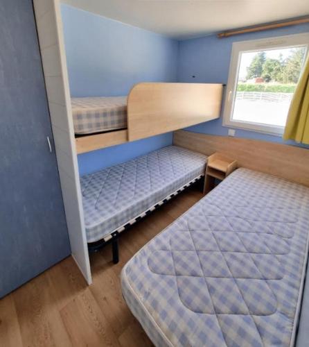 a small room with two bunk beds and a window at DOMAINE DE LA GRANGE DES CHAMPS in Lorris