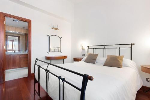 Un dormitorio con una gran cama blanca y una ventana en Chalet Vacacional El Agujero, en Gáldar