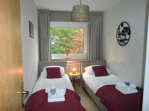 two beds in a small room with a window at Appartementen Edel in Schmallenberg