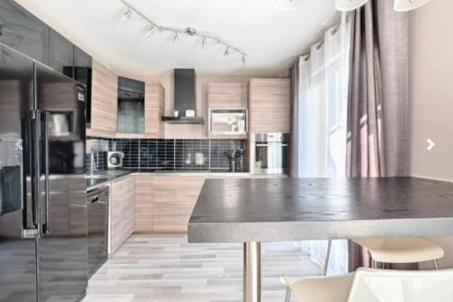 a kitchen with stainless steel appliances and a large island at Maison 120 m² à Vigy in Vigy