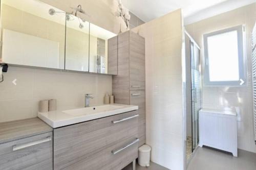 a white bathroom with a sink and a shower at Maison 120 m² à Vigy in Vigy
