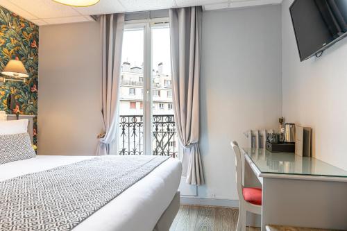 a bedroom with a bed and a desk and a window at Splendid Hôtel in Paris