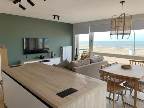 Les pieds dans le sable في دي بان: مطبخ وغرفة معيشة مطلة على الشاطئ