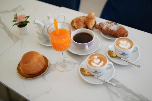 einen Tisch mit Tassen Kaffee, Croissants und Kaffee in der Unterkunft Marchese 124 in Bari