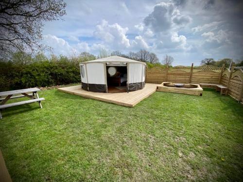 a tent sitting on a deck in a yard at Between Rivers Camping @ The Old George Inn in Sykehouse