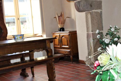 a room with a piano and a table with flowers at Maison Saint James in Saint-James