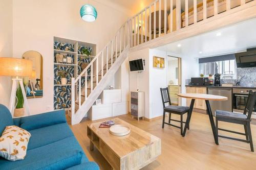 un salon avec un canapé bleu et une table dans l'établissement Le Charme, à Dijon