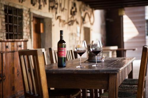 フマーネにあるAzienda Agrituristica Corteforteの木製テーブルにワイン1本とグラス2杯