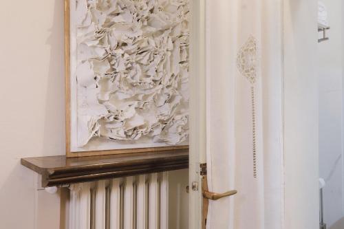 a painting hanging on a wall next to a door at Foresteria Palazzo Guazzoni Zaccaria in Cremona