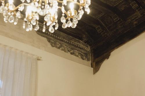 a chandelier hanging from a ceiling in a room at Foresteria Palazzo Guazzoni Zaccaria in Cremona