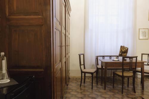 a dining room with a table and chairs at Foresteria Palazzo Guazzoni Zaccaria in Cremona