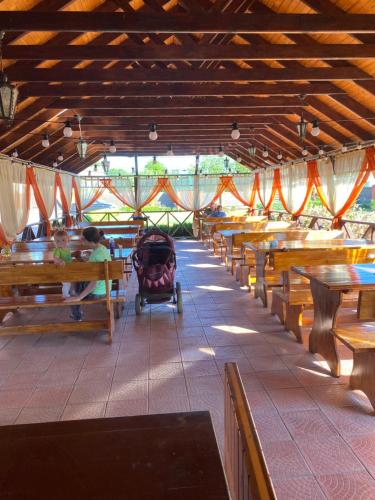 a restaurant with wooden benches and a baby in a stroller at Зелений Клин in Gubnik