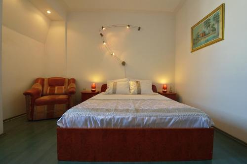 1 dormitorio con 1 cama grande y 1 silla en Atlas Accommodation, en Bucarest