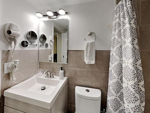 uma casa de banho com um lavatório e uma cortina de chuveiro em Miami Townhouse with Patio, Gazebo, Free Parking, centrally located em Miami