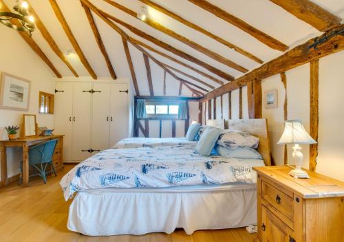 a bedroom with a large bed with blue sheets at Hartley Dyke Barn in Cranbrook