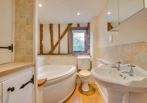 a bathroom with a tub and a toilet and a sink at Hartley Dyke Barn in Cranbrook