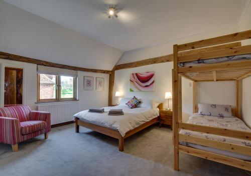 1 dormitorio con litera y silla en Hawkridge Oast, en Sissinghurst