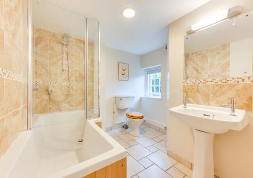 Un baño con lavabo, ducha e inodoro. en Garden Flat, en Sandwich