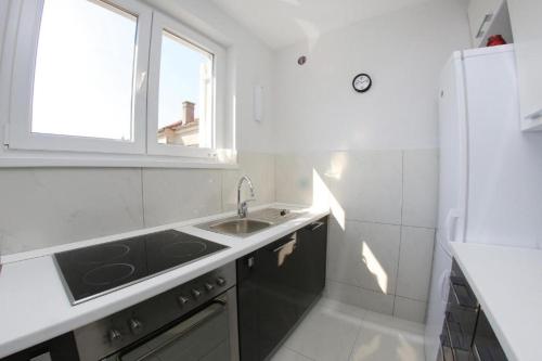 a white kitchen with a sink and a window at Lila1 Apartments in Zadar
