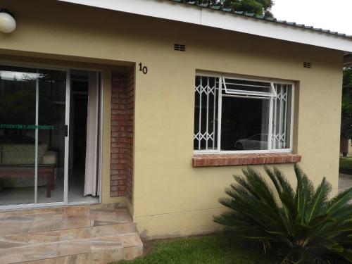 a window on the side of a house at 2 bedroomed apartment with en-suite and kitchenette - 2065 in Harare