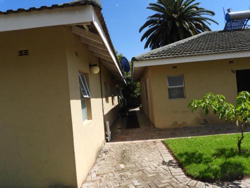 a side view of a house with a driveway at 2 bedroomed apartment with en-suite and kitchenette - 2065 in Harare