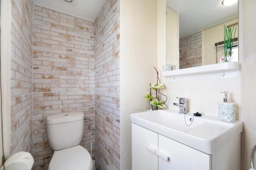 a bathroom with a white toilet and a sink at Villa roulotte - Sólo familias in Chiclana de la Frontera