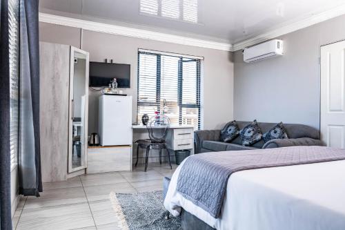 1 dormitorio con 1 cama y sala de estar en Greenlake Guesthouse, en Maseru