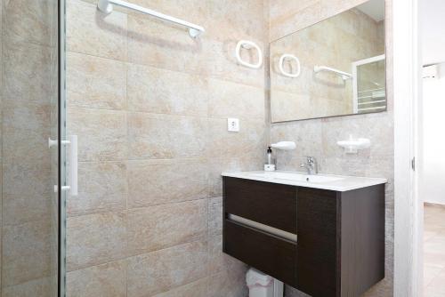 a bathroom with a sink and a mirror at Casa Josisa - Solo Familias in Conil de la Frontera