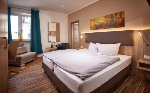 een hotelkamer met een bed en een stoel bij Hotel zum Stern in Schweich