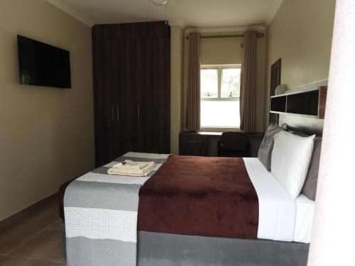 una camera d'albergo con letto e finestra di 2 Bed Apt with en-suite and kitchenette - 2066 a Harare