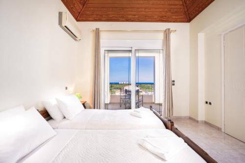 sypialnia z 2 łóżkami i widokiem na ocean w obiekcie Wonderful Villa in Chania with Private Pool, Panoramic Sea Views & Spacious Interiors w mieście Agios Onoufrios