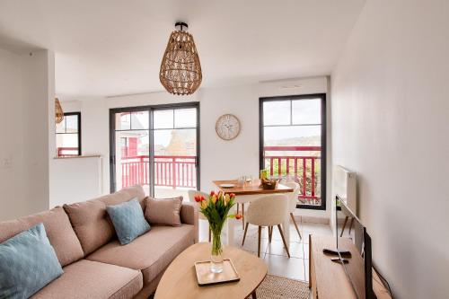 un salon avec un canapé et une table dans l'établissement Évasion à 2 en bord de mer, 50m de la plage, à Pléneuf-Val-André