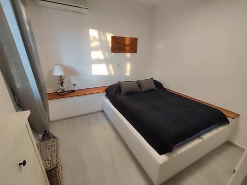 - une chambre avec un lit et une couverture noire dans l'établissement Seaside Serenity, à Skiros