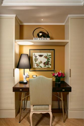 a desk with a lamp and a chair in a room at Rocco Forte Hotel De Russie in Rome