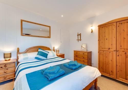 a bedroom with a bed and a dresser and a mirror at Fishermans Cottage in Kingsdown