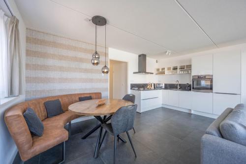a kitchen and dining room with a wooden table and chairs at Meerzicht 24 - Luxury family accommodation with beautiful lake side view in Uitgeest