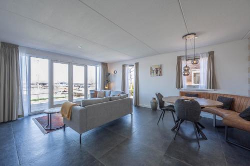 a living room with a couch and a table at Meerzicht 24 - Luxury family accommodation with beautiful lake side view in Uitgeest