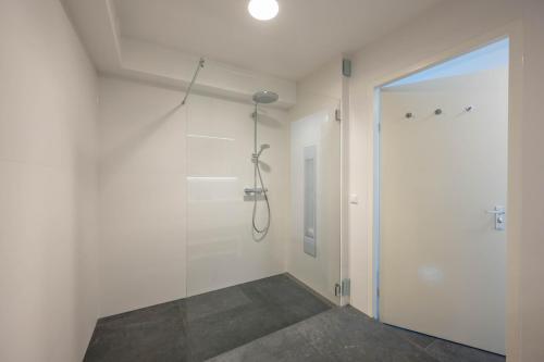 a bathroom with a shower and a glass door at Meerzicht 24 - Luxury family accommodation with beautiful lake side view in Uitgeest