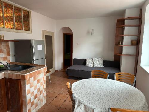 a kitchen and a living room with a table and a couch at Hostel Museum in Koper