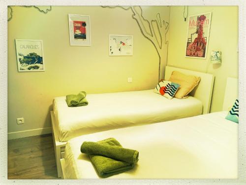 une chambre avec deux lits et un arbre sur le mur dans l'établissement Le Patio - n°13206010120SB, à Marseille