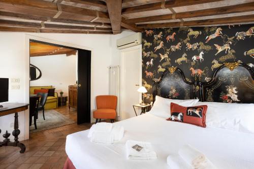 - une chambre avec un grand lit et un mur avec des chevaux dans l'établissement Frattina Apartments, à Rome