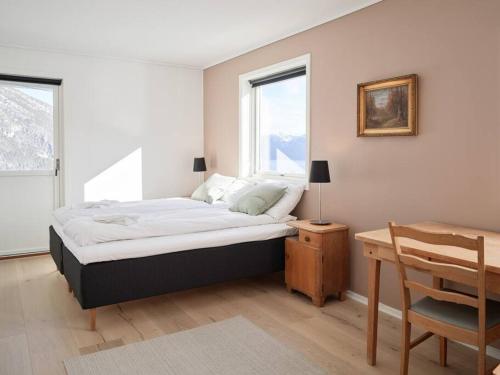 a bedroom with a bed and a table and a window at Fjord Panorama in Stranda