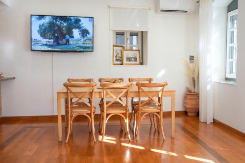 a dining room with a table and four chairs at Naias Aegina, Sea-front apartment 95 sqm in Aegina Town