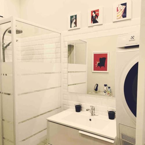 une salle de bain blanche avec un lavabo et un miroir dans l'établissement Le Patio - n°13206010120SB, à Marseille