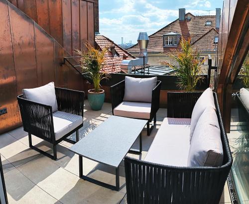 a patio with chairs and tables on a balcony at Boutique Hotel Krone München in Munich