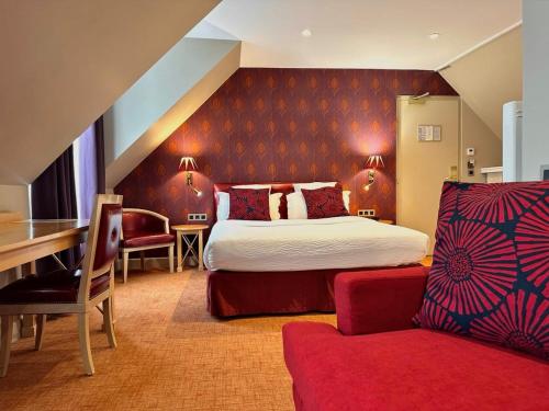 パリにあるオテルセントラル サンジェルマンのベッド、デスク、椅子が備わるホテルルームです。