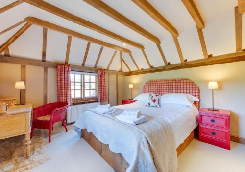 a bedroom with a large bed and a desk at Iden Green Farm Stables in Benenden
