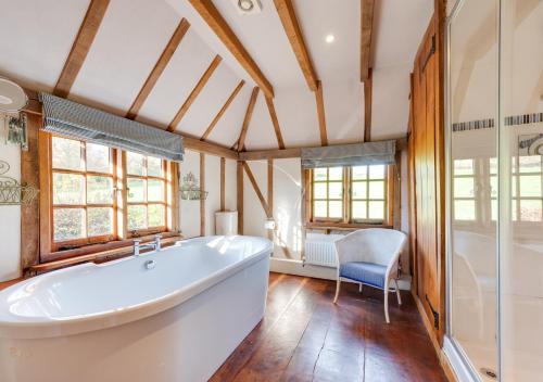 a large bathroom with a tub and a chair at Iden Green Farm Stables in Benenden