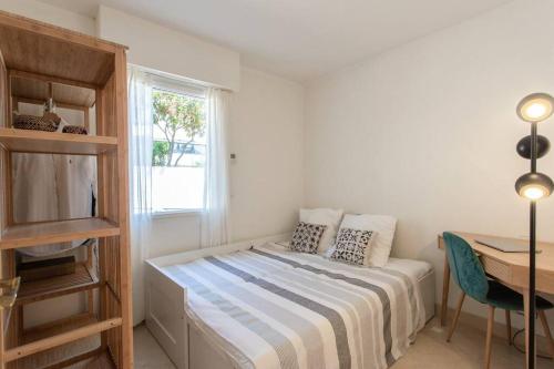 um quarto com uma cama, uma secretária e uma janela em L34 Hermès Suite terrace parking AC 2mins SEA em Saint-Jean-Cap-Ferrat