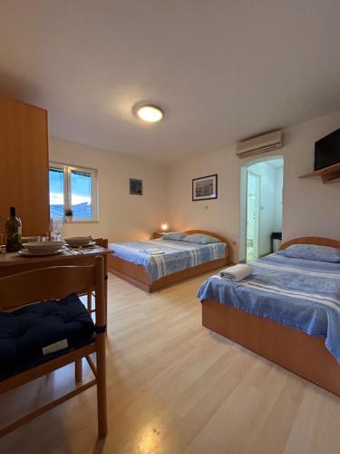 ein Hotelzimmer mit 2 Betten, einem Schreibtisch und einem Zimmer in der Unterkunft Apartment Alfirev Vodice in Vodice